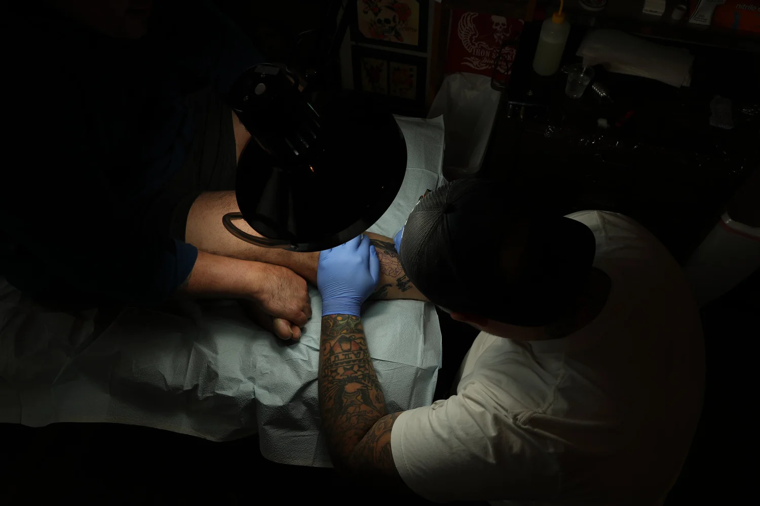 Steadfast artist tattooing a client